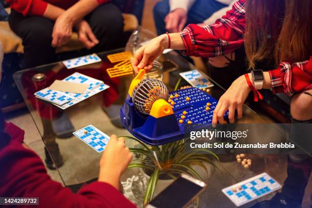 gathered family sharing a board game together - kin in de hand stock-fotos und bilder