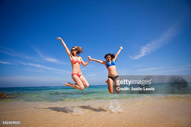 young girls jumping & smiling in sea of cortez - océano pacífico fotografías e imágenes de stock