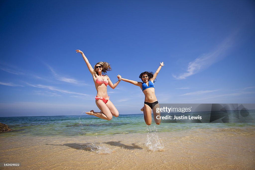 Young girls jumping & smiling in Sea of Cortez