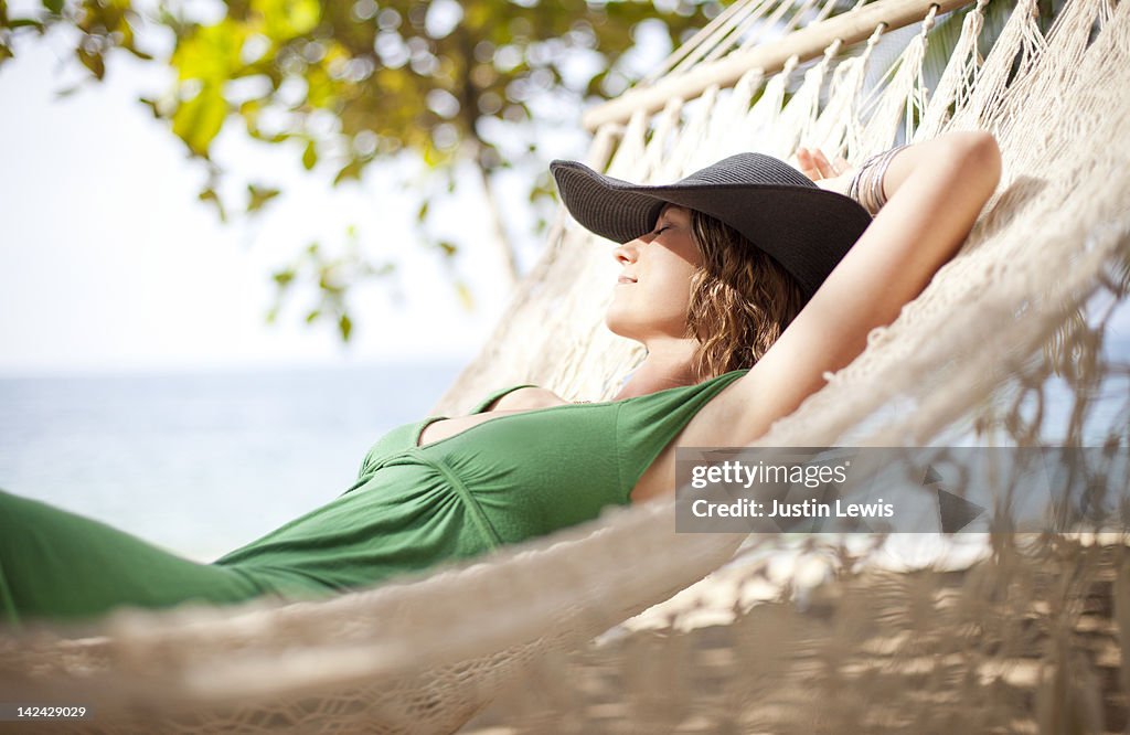 Girl resting on hammock by the beach