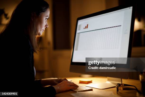 femme sérieuse travaillant tard à la maison - bilan photos et images de collection