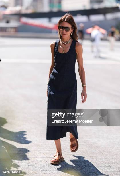 Guest is seen wearing brown shades, gold necklaces, dark blue denim long dress and brown leather sandals, outside Jason Wu show, during New York...