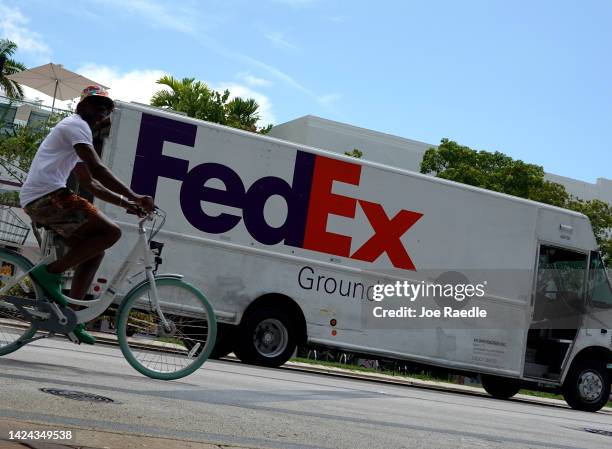 Bicyclist rides past a FedEx truck on September 16, 2022 in Miami Beach, Florida. Shares of FedEx fell after the company missed estimates on revenue...