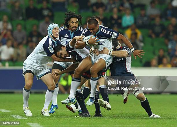 Rudi Wulf of the Blues is tackled by his opponents during the round seven Super Rugby match between the Melbourne Rebels and the Auckland Blues at...