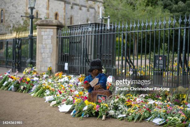 Tributes and a floral paddington Bear for Queen Elizabeth II lay next to the gates of Windsor Castle on September 16, 2022 in Windsor, United...