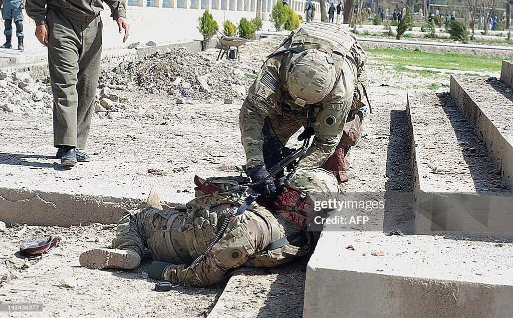 A US soldier helps his colleague, the vi