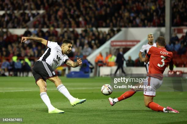 Aleksandar Mitrovic of Fulham shoots under pressure from Steve Cook of Nottingham Forest during the Premier League match between Nottingham Forest...