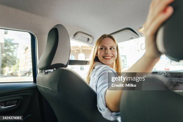 confident young woman driving car - reversing stock pictures, royalty-free photos & images