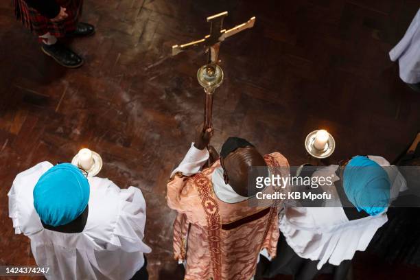 An altar server carries a cross before the start of Queen Elizabeth II's memorial service on September 15, 2022 in Harare, Zimbabwe. Queen Elizabeth...