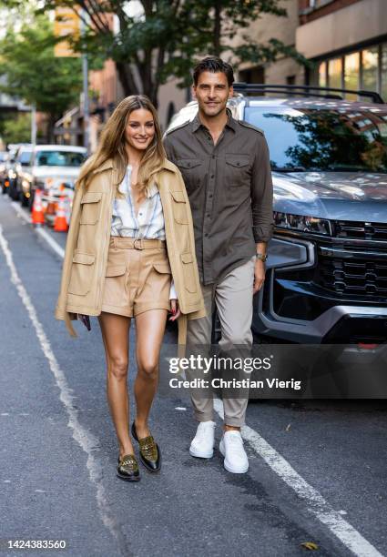 Couple Olivia Palermo wearing beige jacket, shorts, striped button shirt, loafers & Johannes Huebl wearing grey jacket, pants outside Jonathan...