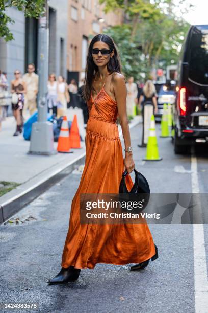 Babba Rivera wearing rust brown dress, black bag outside Jonathan Simkhai on September 13, 2022 in New York City.