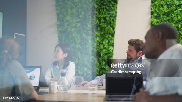 モダンなオフィスのワーキングスペースの会議室でビジネスミーティングを行うビジネスパーソン - サスティナブル ストックフォトと画像