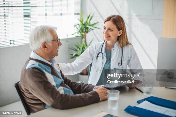 senior men visiting doctor - bezoek stockfoto's en -beelden