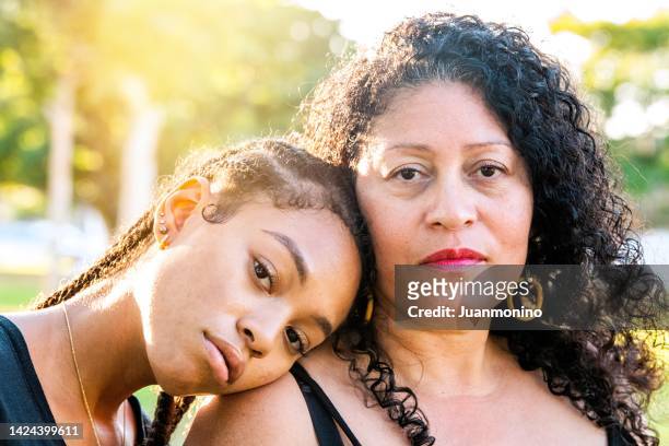 afro-latinx young woman posing with her mother - mother daughter hispanic stock pictures, royalty-free photos & images