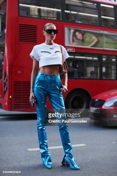Guest is seen wearing a pair of metallic blue leather pants with a white t-shirt at Poster Girl during London Fashion Week on September 16, 2022 in...