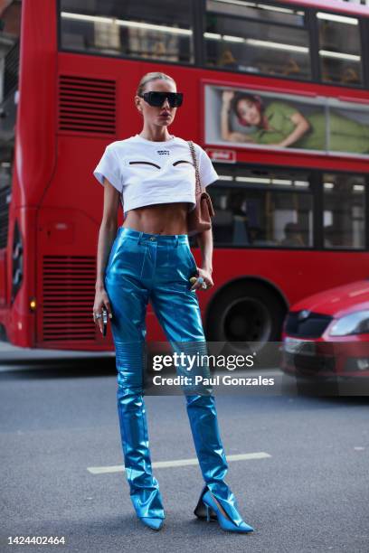 Guest is seen wearing a pair of metallic blue leather pants with a white t-shirt at Poster Girl during London Fashion Week on September 16, 2022 in...