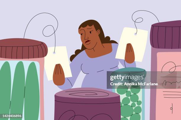 woman of color vergleicht preisschilder im lebensmittelgeschäft während der wirtschaftlichen inflation - thrift shopping stock-grafiken, -clipart, -cartoons und -symbole