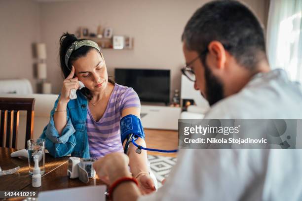 doctor on a house call measuring the blood pressure - arteries stock pictures, royalty-free photos & images