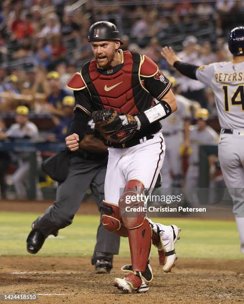 Catcher Carson Kelly of the Arizona Diamondbacks reacts after Jace Peterson of the Milwaukee Brewers scores a run during the ninth inning of the MLB...