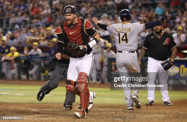 Catcher Carson Kelly of the Arizona Diamondbacks reacts after Jace Peterson of the Milwaukee Brewers scores a run during the ninth inning of the MLB...