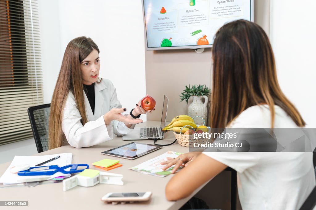 Nutritionist attending to client in her office