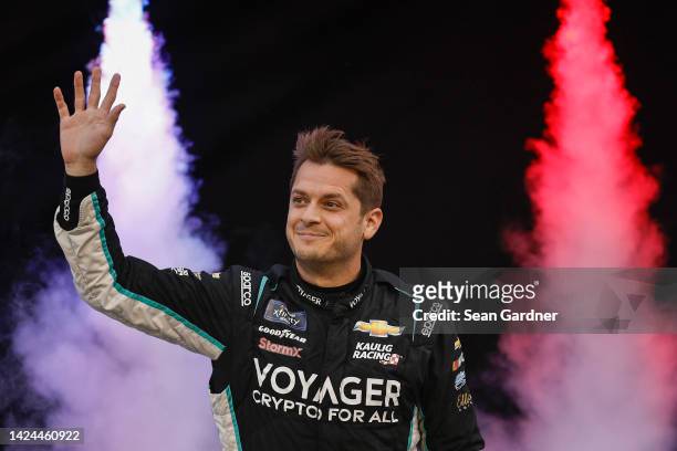 Landon Cassill, driver of the Voyager: Crypto for All Chevrolet, waves to fans as he walks onstage during driver intros prior to the NASCAR Xfinity...