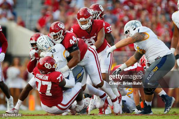 Defensive linemen Jeffery Johnson and Kelvin Gilliam Jr. #44 of the Oklahoma Sooners tackle running back Marquez Cooper of the Kent State Golden...