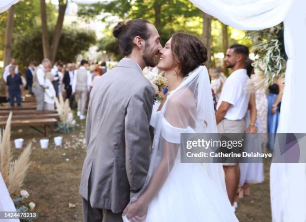 a newlywed couple embracing during their wedding ceremony - casados fotografías e imágenes de stock