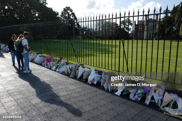 People gather to look at floral tributes for the late Queen Elizabeth II outside New South Wales Government House on September 17, 2022 in Sydney,...