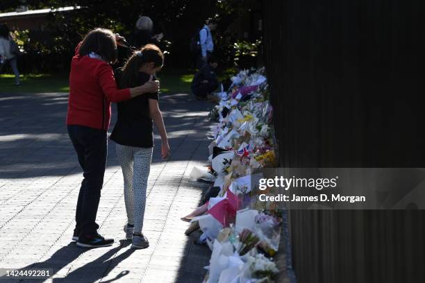 Woman puts her arm around a child as they look at floral tributes outside New South Wales Government House on September 17, 2022 in Sydney,...