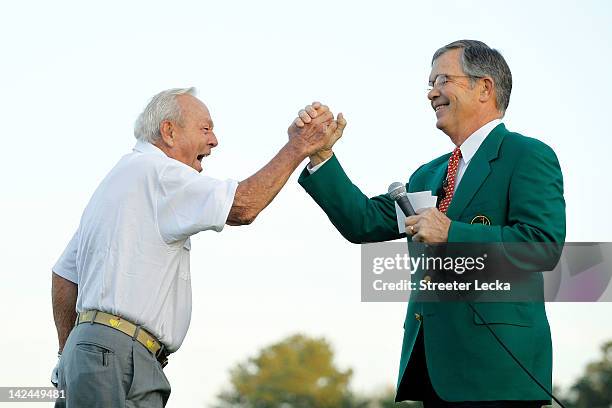 Augusta National Golf Club chairman William Porter Payne high fives honorary starter Arnold Palmer after his tee shot on the first hole during the...