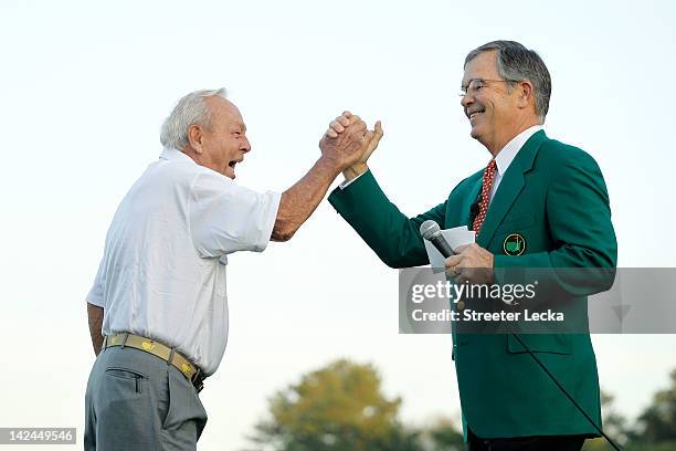 Augusta National Golf Club chairman William Porter Payne high fives honorary starter Arnold Palmer after his tee shot on the first hole during the...