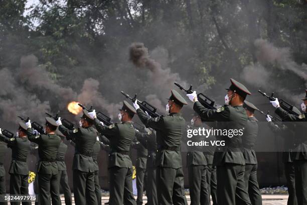 Chinese honour guards fire a gun salute during a burial ceremony for the remains of 88 Chinese soldiers who died during the Korean War at the Chinese...