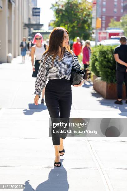 Gala Gonzalez wearing black white checkered top, high waisted black pants, black bag outside Michael Kors on September 14, 2022 in New York City.