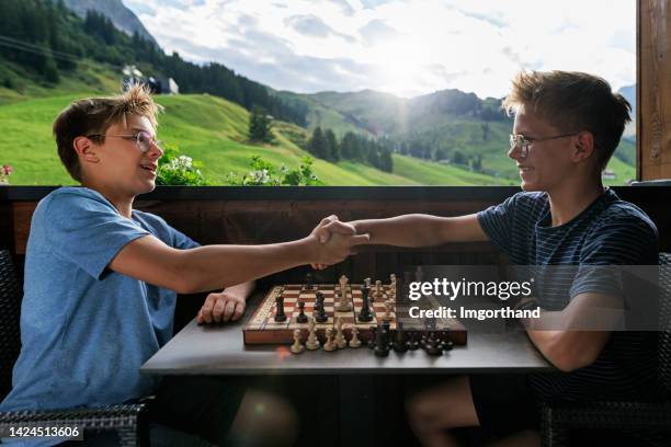 teenage boys playing chess on the balcony - tie game stock pictures, royalty-free photos & images