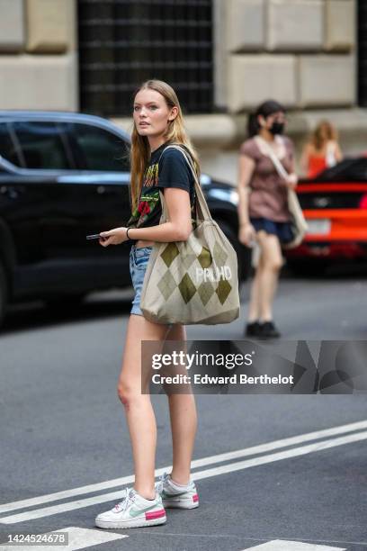 Guest wears a black with yellow and green print pattern t-shirt, blue denim shorts, a beige and khaki checkered print pattern oversized cotton...