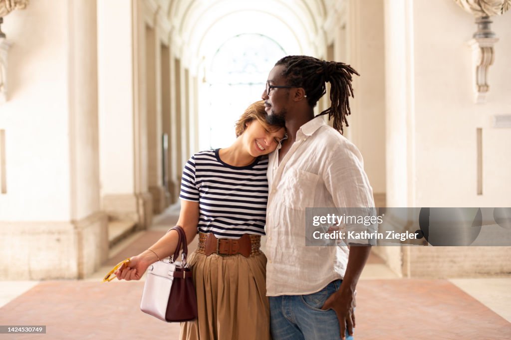 Happy affectionate couple in sunlit entrance hall