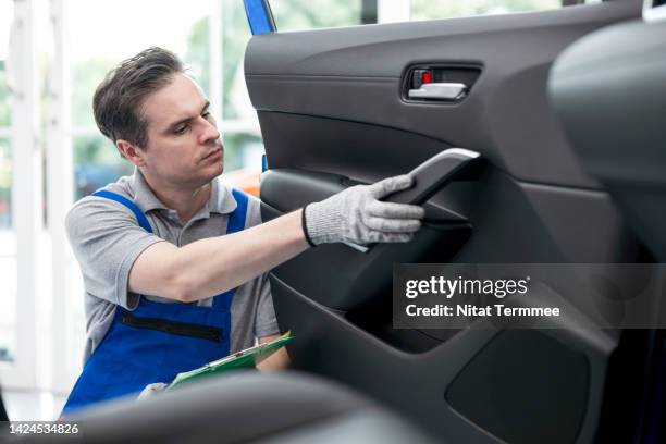 testing interior car door panels efficiently and safely. auto mechanics examining sources of noise in a car door trim interior during servicing periods in an auto repair service center. - weather stripping stock pictures, royalty-free photos & images