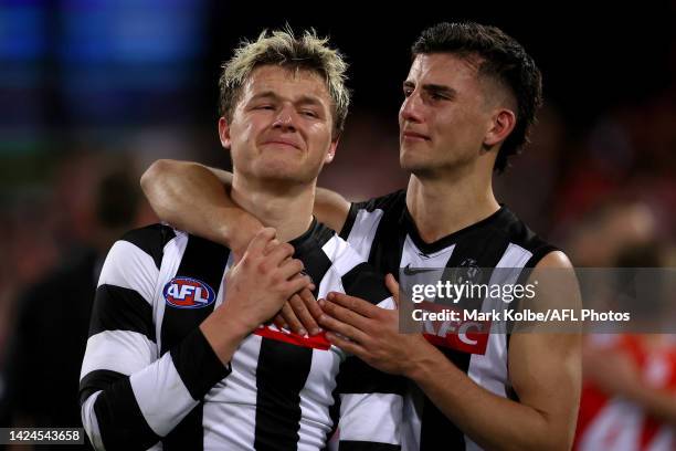 Jack Ginnivan and Nick Daicos of the Magpies embrace as they look dejected after defeat during the AFL Second Preliminary match between the Sydney...