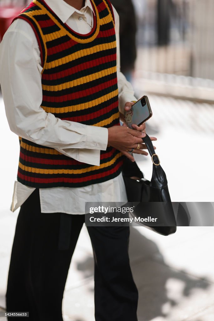 Fashion Week Guest seen wearing a white blouse, black pants, a News