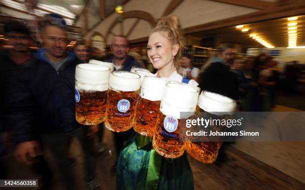 Waitress carries some Mass of beer in the Hofbrauhaus tent on the opening day of the 2022 Oktoberfest beer fest on September 17, 2022 in Munich,...