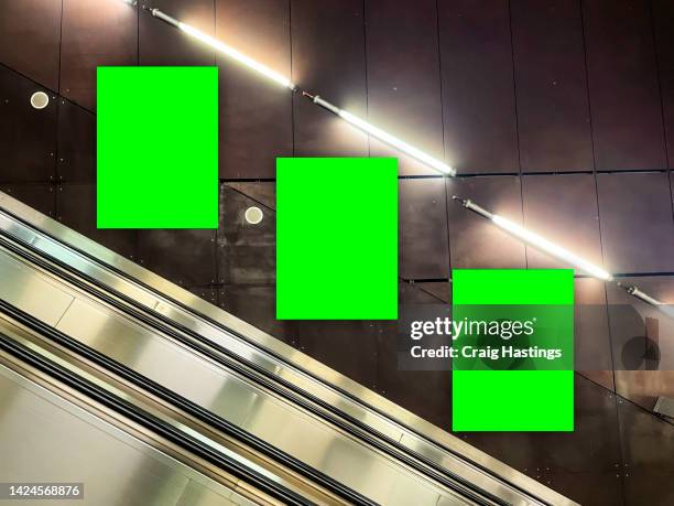 three large size vertical airport information green screen chroma key marketing advertisement billboard in a row in city centre shopping mall, train bus station or airport environment targeting adverts at consumers, retail shoppers, commuters and tourists - display window stock-fotos und bilder