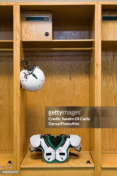 football helmet and shoulder pads in locker room - locker room ストックフォトと画像