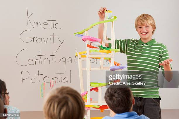 boy talking about gravity in classroom - gravitational field stock pictures, royalty-free photos & images