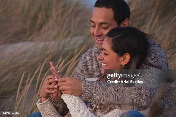 hispanic couple looking at engagement ring - engagement ring foto e immagini stock