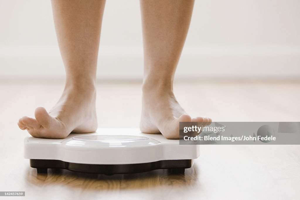 Caucasian woman's feet standing on scale