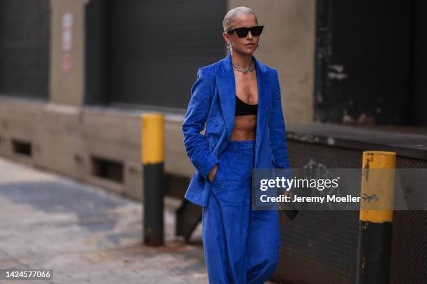 Caroline Daur is seen wearing black shades, large silver earrings and necklace from Tiffany & Co, a royal blue ribbed velvet blazer jacket, matching...