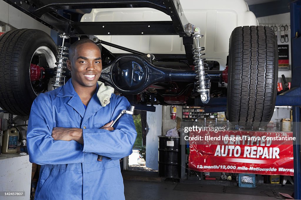 Black mechanic working on car