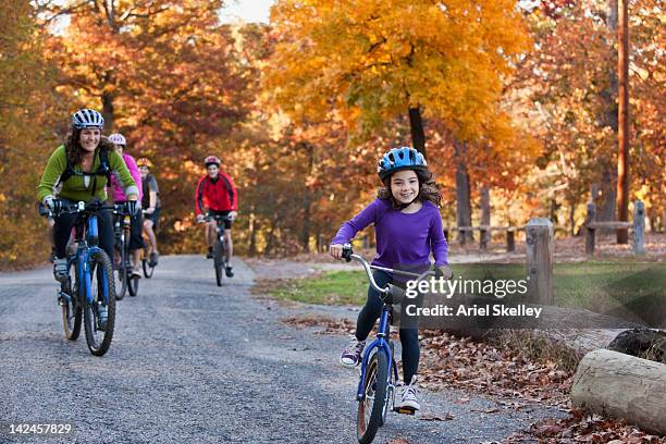 family riding bicycles in park - family biking stock pictures, royalty-free photos & images