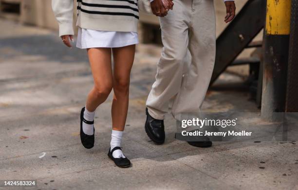Emili Sindlev is seen wearing a white striped wool knit sweater with a zipper, white short skirt, white socks and black Miu Miu ballerinas; Mads Emil...